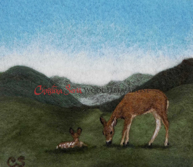 artwork wool painting of a scene of a mother white tailed deer grazing green grass with her fawn on the grass next to her looking into the mountains in the background. Blue skies